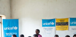 Nigerian students in a classroom with laptops and UNICEF digital skills banners, highlighting the urgent need for tech education
