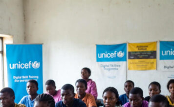Nigeria Faces Digital Skills Emergency, Warns UNICEF Nigerian students in a classroom with laptops and UNICEF digital skills banners, highlighting the urgent need for tech education