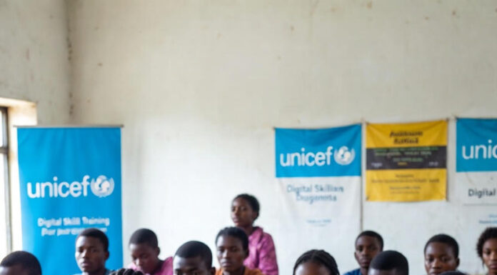 Nigerian students in a classroom with laptops and UNICEF digital skills banners, highlighting the urgent need for tech education