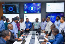 FIRS officials and experts gather in a high-tech command center during the MARCON Retreat, surrounded by large digital screens displaying tax data, analytics, and Nigeria-focused tech solutions.
