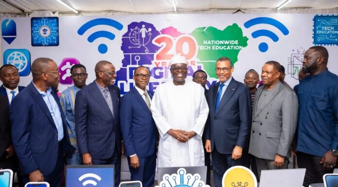 Diverse group of Nigerian tech leaders, entrepreneurs, and developers in a modern office brainstorming around laptops and data charts, symbolizing Nigeria’s ambition to lead Africa in AI innovation.