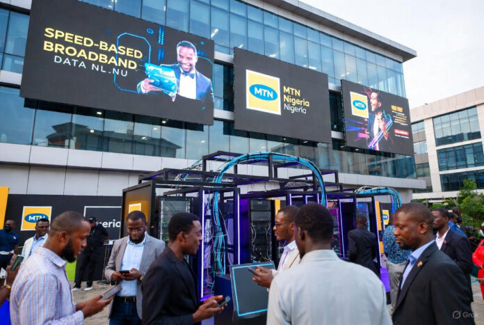 MTN Nigeria Unleashes Unlimited Speed-Tier Broadband Crowd of excited Nigerians outside MTN headquarters in Lagos, with large digital screens announcing “Speed-Based Unlimited Broadband Data Plans”.