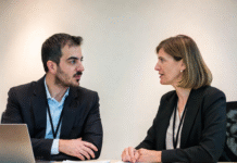Government officials and education technology experts in a formal meeting discussing Nigeria’s new National EdTech Strategy, with laptops, documents, and tablets on the table.
