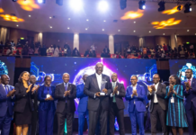 Enoch Ogunnowo Honoured at Nigeria Technology Awards 2023 Enoch Ogunnowo smiling on stage holding the Nigeria Technology Awards 2023 trophy, with bright stage lights and the NiTA logo in the background.