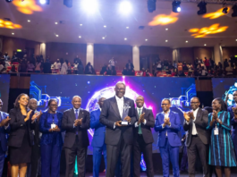 Enoch Ogunnowo Honoured at Nigeria Technology Awards 2023 Enoch Ogunnowo smiling on stage holding the Nigeria Technology Awards 2023 trophy, with bright stage lights and the NiTA logo in the background.