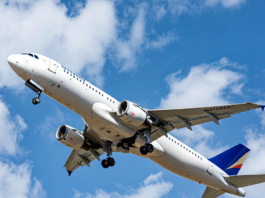 A Nigerian commercial jet taking off against a clear blue sky, with a subtle overlay of a cracked safety checklist and human silhouette, symbolising that human behaviour remains the biggest factor in aviation safety and efficiency.