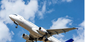 ‘Behaviour, not technology, defines Nigeria’s aviation outlook’ A Nigerian commercial jet taking off against a clear blue sky, with a subtle overlay of a cracked safety checklist and human silhouette, symbolising that human behaviour remains the biggest factor in aviation safety and efficiency.