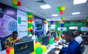 Excited Nigerians at a colourful launch event with green, white and yellow balloons, using laptops to open LemFi USD and GBP global accounts on the app.