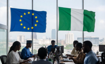 Nigerian and European officials in a modern conference room with EU and Nigerian flags, collaborating on laptops against a Lagos city skyline, symbolising partnership in digital innovation.