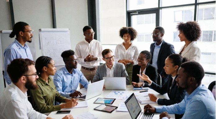 Diverse group of Nigerian tech leaders, entrepreneurs, and developers in a modern office brainstorming around laptops and data charts, symbolizing Nigeria’s ambition to lead Africa in AI innovation.