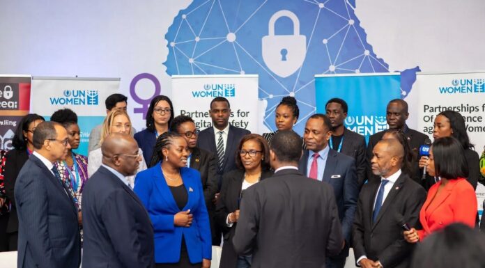 UN Women representatives, Nigerian officials, and activists stand together at a Lagos summit in front of a digital Africa map with shields and locks, symbolizing the fight against online gender violence.