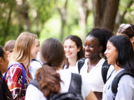 Excited Nigerian schoolgirls wearing safety goggles conducting science experiments with microscopes and test tubes during a hands-on STEM workshop at the WITIN National Summit.